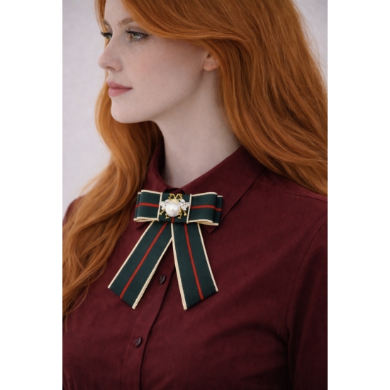 Elegancka broszka w formie kokardy z dekoracyjną perłą – stylowy dodatek inspirowany klasyczną elegancją z wyrazistym charakterem.